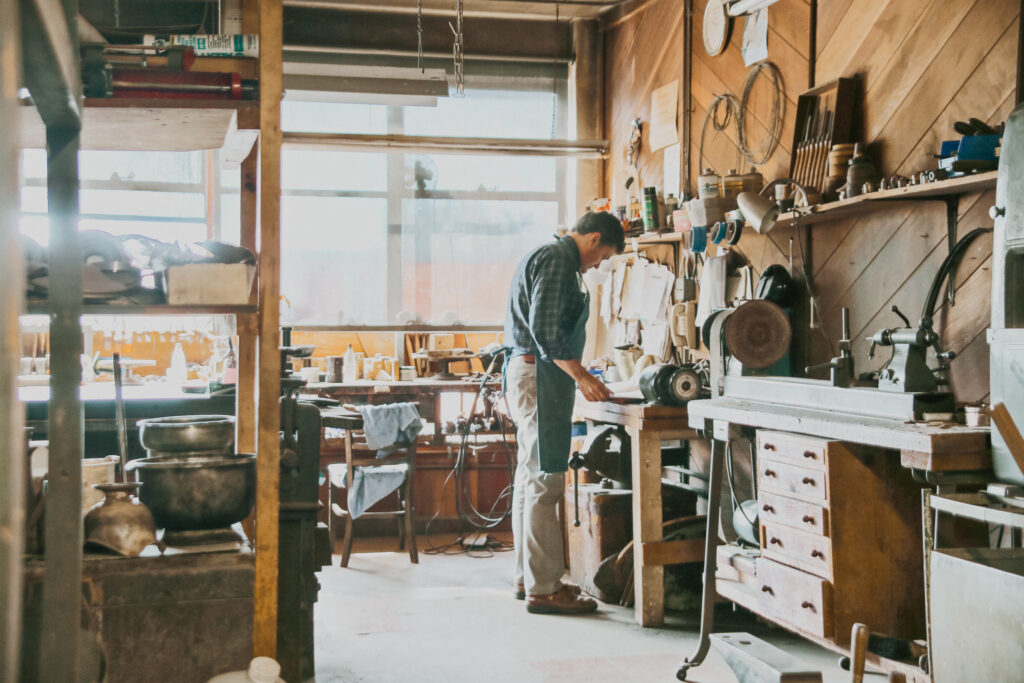 Silversmith working on silver restoration in the workshop